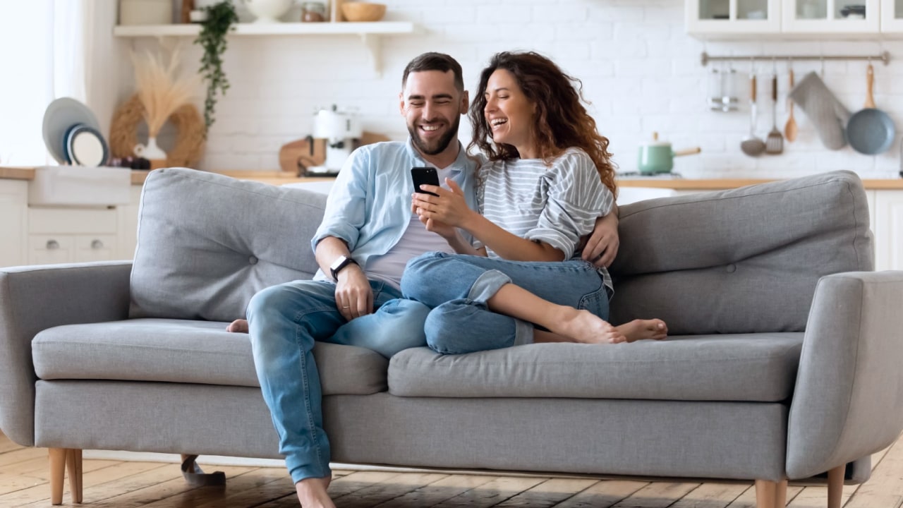 Couple on the couch looking at cell phone