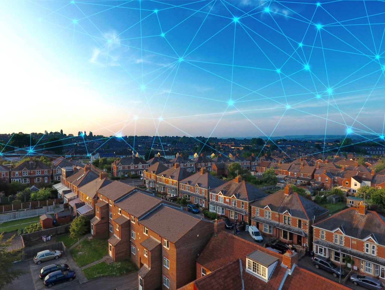 Aerial view of parking and roof tops of a housing development with an electrical network represented overhead