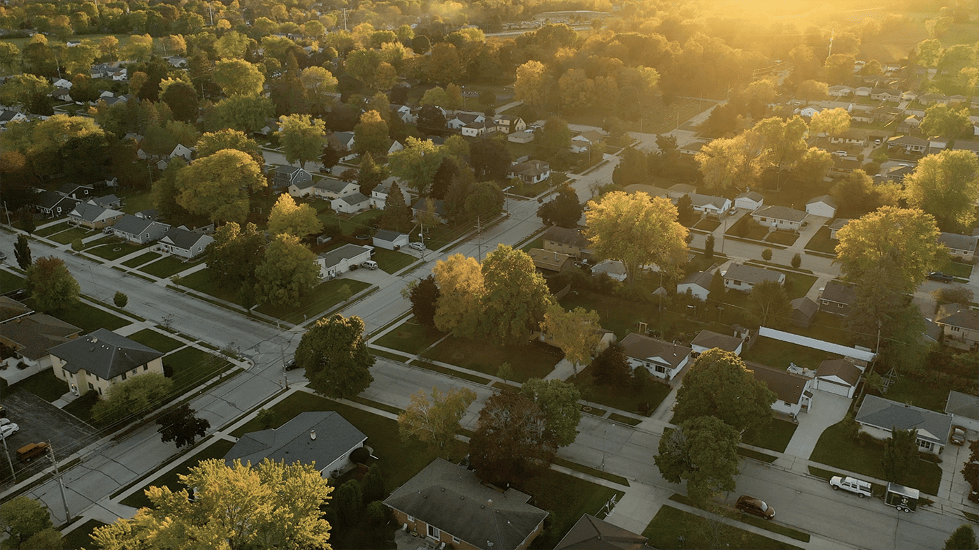 Aerial view of a picturesque fall residential neighborhood showcasing vibrant autumn foliage and cozy homes.