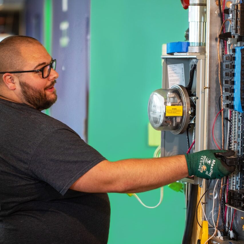 A Ting employee working on an electrical wall panel